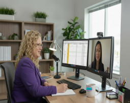 Consulting TAG and video call 2 computer screens at desk taking notes